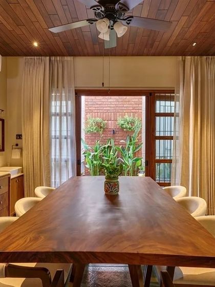 The dining room opens onto a small internal courtyard, bringing natural light and a touch of green into the space.