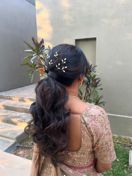 A view of the romantic ponytail in an outdoor setting, showing how it complements the client's embellished lehenga.