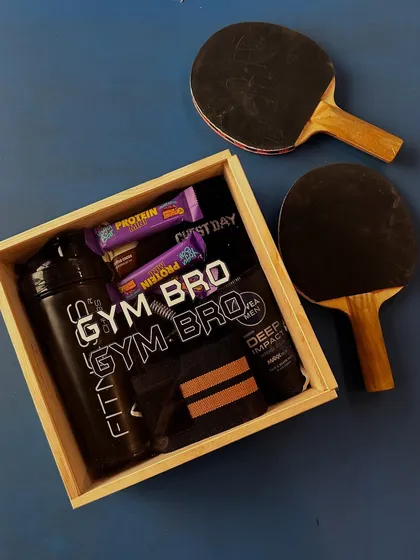 For the brother who lives at the gym, I designed this "Gym Bro" hamper. It's packed with practical fitness essentials like a protein shaker, grip gear, protein bars, and even some skincare, all presented in a custom wooden box.