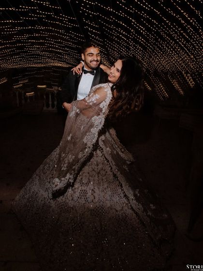 A playful and romantic portrait of the couple dancing under a tunnel of lights.