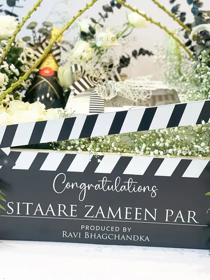 This shot focuses on the custom-printed clapperboard that forms the centerpiece of the film-themed hamper. It clearly displays the congratulatory message, showcasing my ability to integrate personalized branding directly into the gift design.