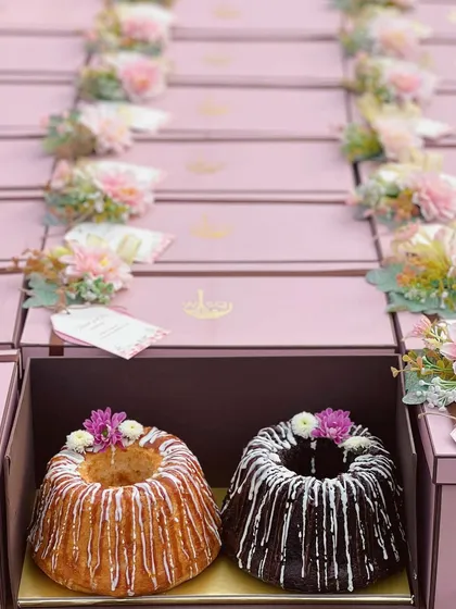 My twin cake sets are perfect for return favors or when you simply can't choose just one. Pictured here are my vanilla and chocolate bundt cakes, drizzled with icing and packed in beautiful pink gift boxes adorned with fresh flowers.