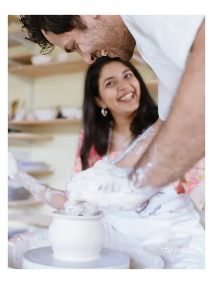 Pre-wedding shoots can be a fun activity you do together. Here, the couple shares a laugh during a pottery session, resulting in authentic, joyful photos that tell a story of creating something beautiful together.