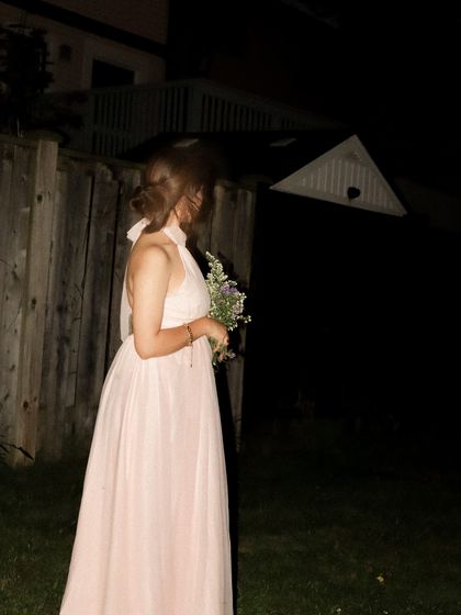 A side profile of the pink dress, showing the flow of the tulle fabric.