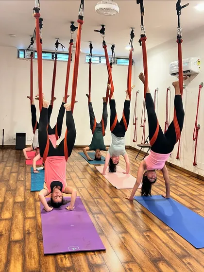 A group of students in a synchronized aerial inversion, a testament to the focus and coordination we build in class.