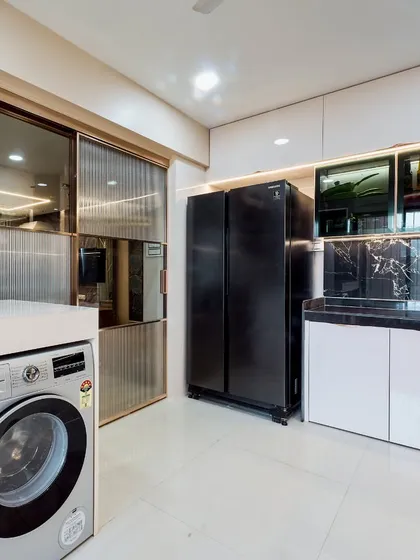 A utility area within the kitchen, showing how I integrate appliances like the washing machine and refrigerator seamlessly. The fluted glass sliding door adds a stylish touch.