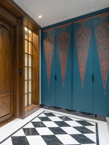 First impressions matter. In this Hyderabad foyer, what appears to be a beautiful, hand-painted art panel is actually a concealed shoe cabinet, blending functionality with the intricate beauty of Indian miniature art to create a stunning and practical entrance.
