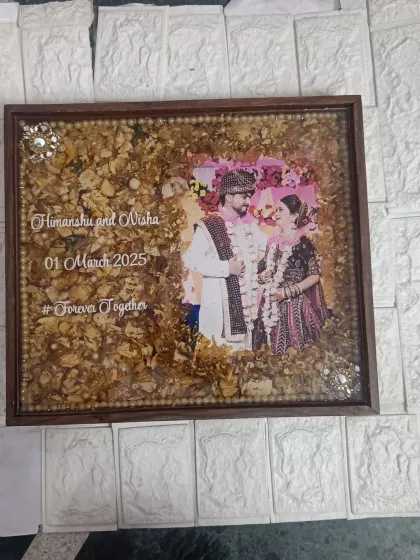 A rectangular wedding frame preserving delicate white and yellow flowers. The couple's names, wedding date, and hashtag are elegantly written on the clear resin over their photo.