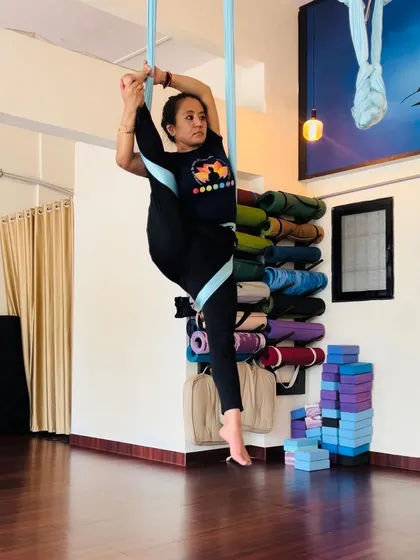 The hammock provides support to explore poses that challenge both strength and flexibility. This standing split variation helps improve balance and mobility in a controlled way.