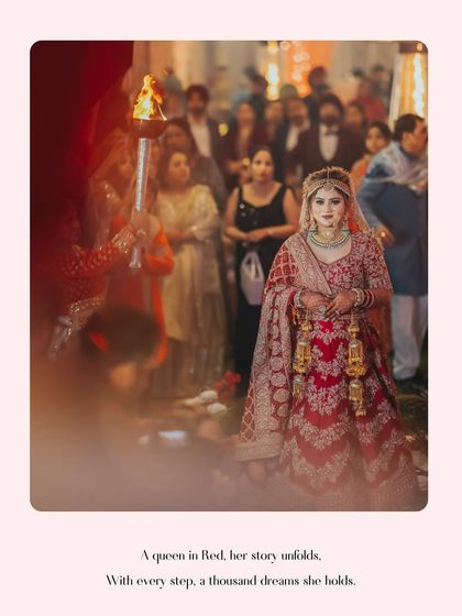 A full-length shot of Gurbani's bridal entry, her red lehenga standing out as she walks down the aisle, ready to meet her groom.