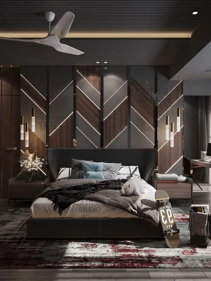 This dark and moody bedroom is perfect for a young client. It features a unique chevron-patterned wall with integrated lighting, a comfortable seating area, and a dedicated workspace.