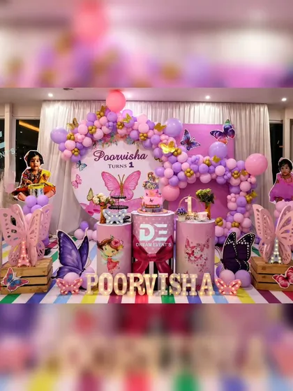 A dreamy butterfly-themed first birthday party that's as magical as it is beautiful. This setup features a stunning purple and pink balloon arch, custom name and age displays, and whimsical butterfly cutouts to create an enchanted garden atmosphere.