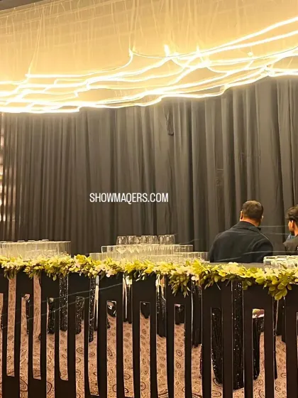 This bar setup for an evening reception features modern, clean lines with floral decorations and unique overhead lighting. It’s designed to be both functional and a beautiful part of the overall decor.