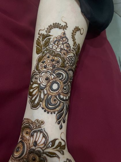 A beautiful floral and vine composition on the arm, typical of the elegant Doha and Gulf styles.