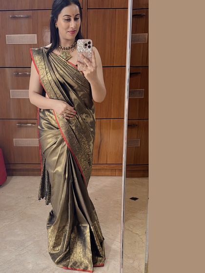 Dr. Shruthi Chethan exudes timeless elegance in this regal black and golden designer silk saree with a bold red border.
