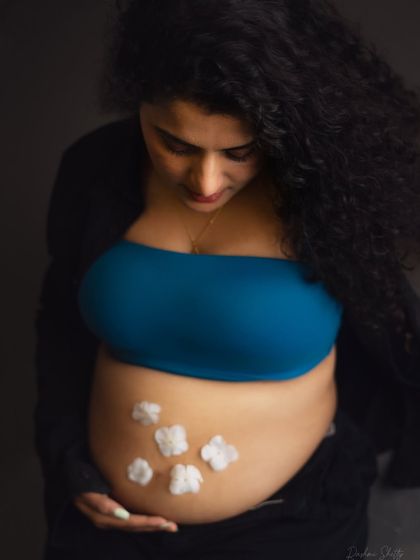 A creative and sweet way to announce a baby boy. The little cotton flowers on the baby bump are a delicate touch in this modern, casual maternity portrait.