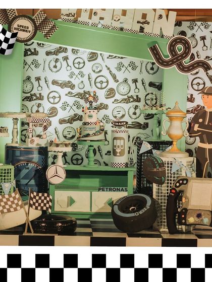 A detailed look at the F1-themed dessert station, featuring a custom backdrop, themed treats, and props like tires and a steering wheel. Every detail is on-theme.