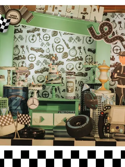 A detailed look at the F1-themed dessert station, featuring a custom backdrop, themed treats, and props like tires and a steering wheel. Every detail is on-theme.