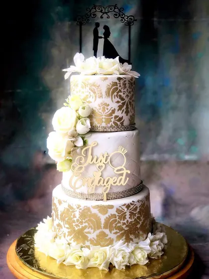Another perspective of the three-tiered engagement cake, highlighting the silhouette topper and the shimmer of the crystal bands.