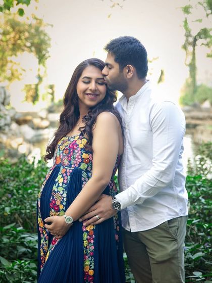 A tender forehead kiss in a lush garden setting. These simple gestures of love make for the most heartfelt and timeless couple maternity portraits.