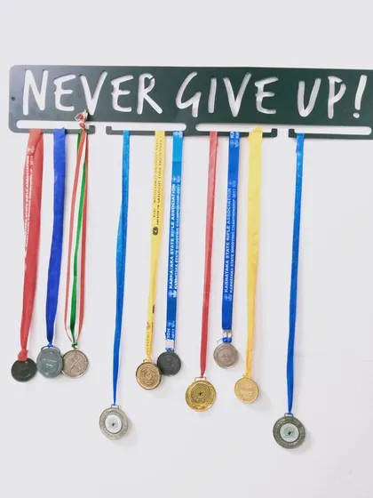 This is the mindset we instill in all our athletes. The medals hanging below are not just awards; they represent countless hours of practice, resilience, and the refusal to give up on the path to excellence.