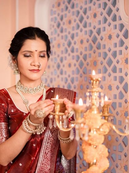 A serene moment captured as the model in the Navari saree lights a candle, perfect for a traditional themed shoot.