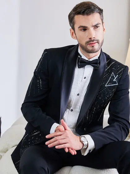 A portrait that exudes confidence. The bespoke fit of the embellished tuxedo is evident, creating a look that is both powerful and graceful for the groom or his squad.
