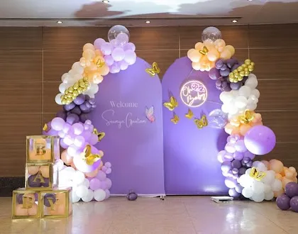 Another shot of the purple butterfly welcome party, showing the neon sign and "BABY" blocks.