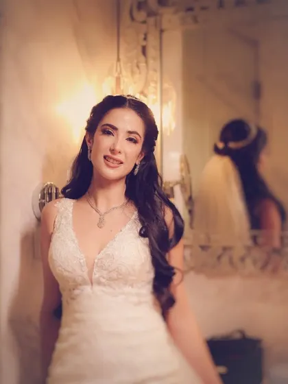 A smiling portrait of a bride in her white wedding dress.