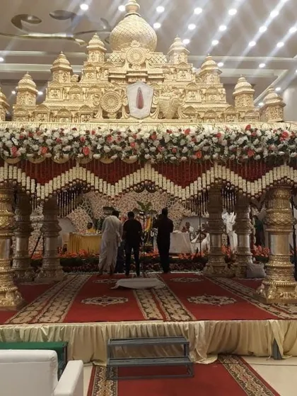 This is a great example of a grand, temple-style wedding mandap I designed. The intricate golden structure, combined with traditional red and white floral garlands, creates a divine and opulent atmosphere for the main ceremony.