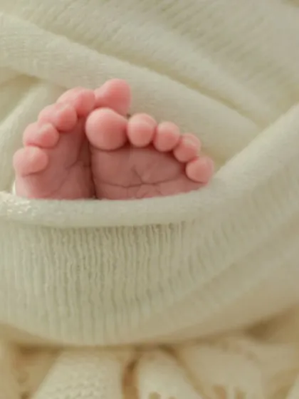 The tiniest details hold the biggest love. A close-up of your newborn's perfect little feet, nestled in a soft wrap, is a simple yet profound reminder of how small they once were. These detail shots are a cherished part of every newborn session.