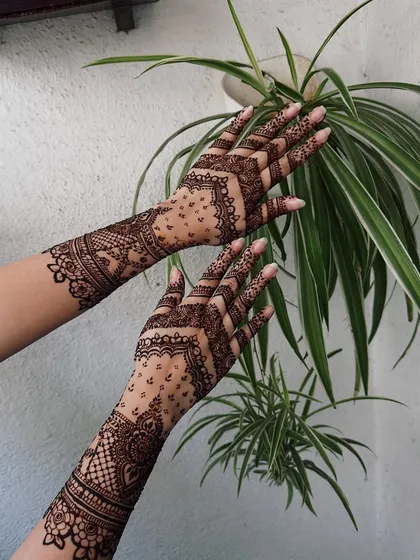 The chevron patterns on the fingers lead into a detailed wrist cuff and forearm design, demonstrating how I build layers of traditional henna art.