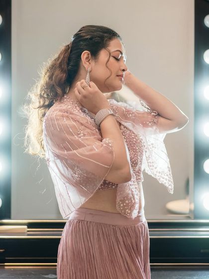 A side profile showing the delicate embroidery on the cape and the elegant ponytail hairstyle.