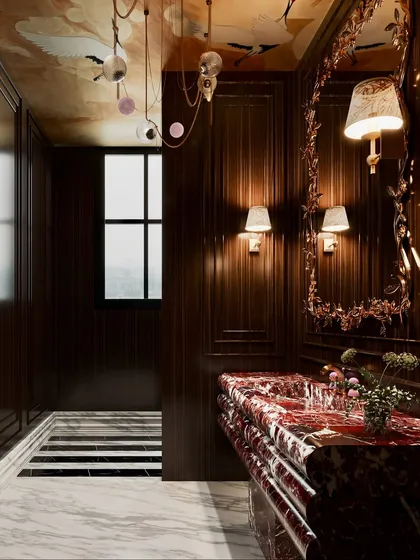 Another angle of the dramatic washroom, this shot captures the light from the window and the intricate details of the wall sconces and mirror frame.