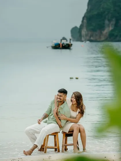 A serene moment on the shores of Phi Phi island. The traditional long-tail boat in the background instantly places their love story in the heart of Thailand, creating a beautiful travel memory.