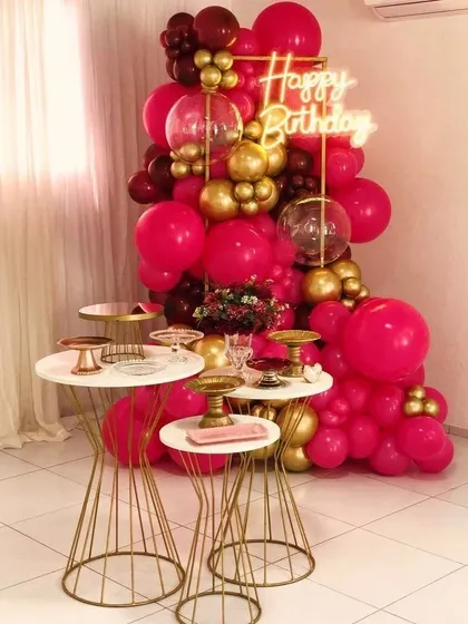 Bold and beautiful. This party decor makes a statement with a dramatic balloon arrangement in hot pink and gold, perfect for someone who loves a touch of glamour and vibrant color.