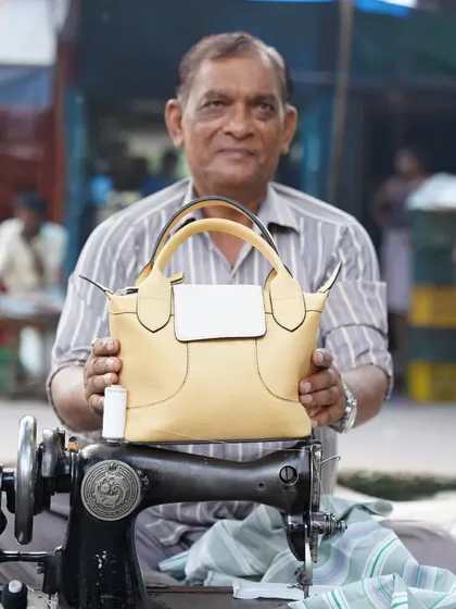 The Stella Crossbody in Buttercup, held by one of the artisans who helped create it. This bag features a classic design with clean lines, perfect for a casual day out when you only need the essentials.