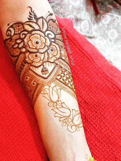 A heavy start-up design for the forearm, featuring a bouquet of roses and jhumkas. This is a great option for someone who wants a statement piece without covering the entire hand.
