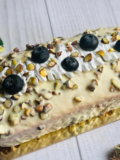 This Lemon, Pistachio, and Blueberry Loaf offers a perfect balance of sweet and tangy flavors. The loaf is topped with a white chocolate glaze, roasted pistachios, and fresh blueberries.