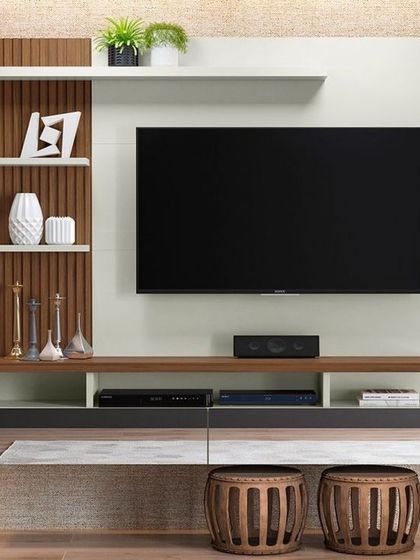 Another variation of a wall-mounted TV unit. This design incorporates vertical wood fluting and a mix of white and grey-toned drawers, creating a textured and visually interesting piece that is also highly functional.