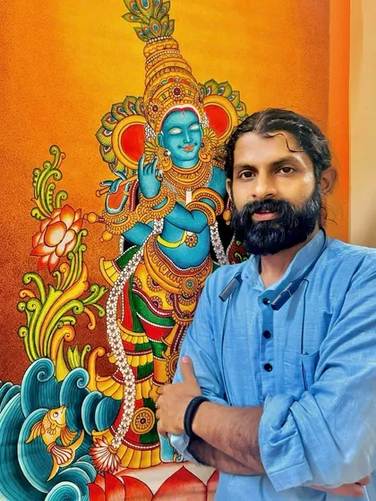 A self-portrait with a recently completed Krishna painting, showing him by the water. Good morning, dear friends.