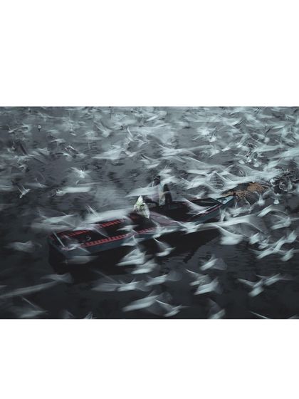 A motion-blurred shot of birds and boats on the Yamuna, creating an abstract and chaotic image that conveys the energy of the ghat.