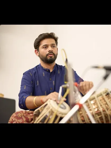 A close-up shot of me playing, listening intently to the sitar to provide responsive and supportive accompaniment.