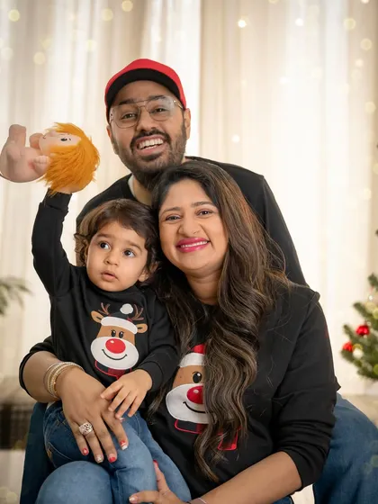A classic family Christmas portrait with everyone smiling for the camera. The matching sweaters and festive props add a touch of holiday fun.