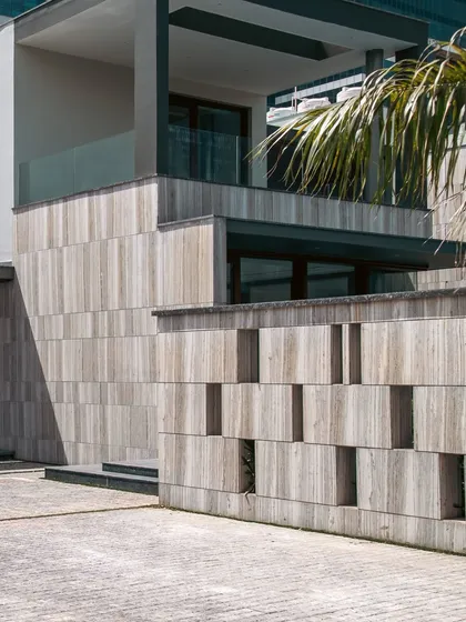 The boundary wall at Rosewood Farmhouse features a unique perforated design in stone. This detail adds a layer of texture and visual interest to the approach while maintaining a sense of privacy.