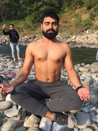 Meditating on a bed of river stones. Connecting with nature during mindfulness practice can deepen the experience, helping to achieve a state of peace that comes from understanding and acceptance.