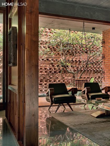 Looking from the interior living space out into a courtyard. The perforated brick wall allows for light and air circulation while providing a beautiful backdrop for the trees, demonstrating how landscape and architecture can work together.