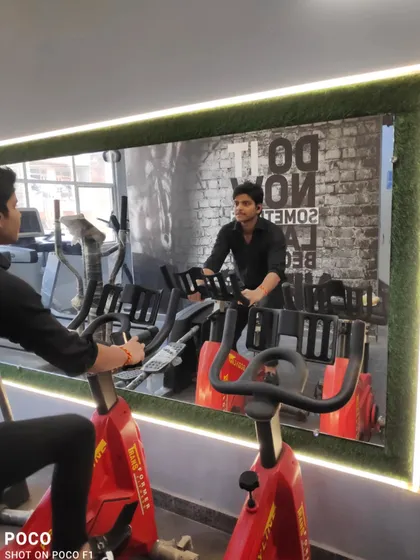 A client putting in the work on the stationary cycle. Cardio is a vital part of any transformation workout plan for improving heart health and burning fat.