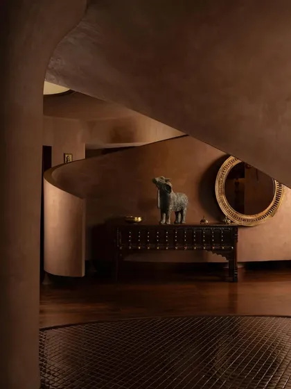 A vignette showing a traditional console table and mirror, set against the backdrop of the store's curving, sculptural walls.