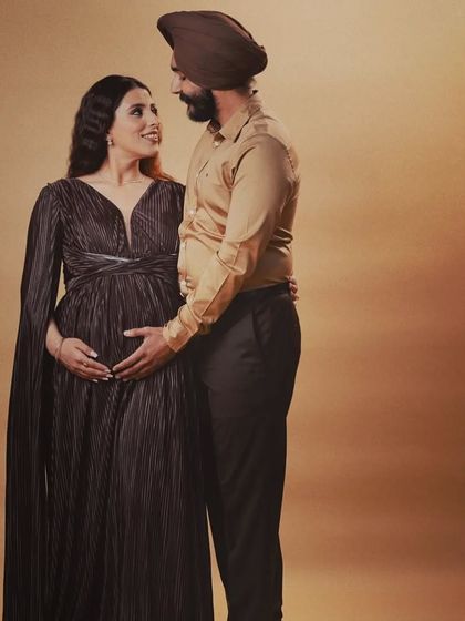 The loving gaze between partners says it all. This couple's studio shoot was full of warmth, and the elegant pleated gown was the perfect choice for their timeless portraits.